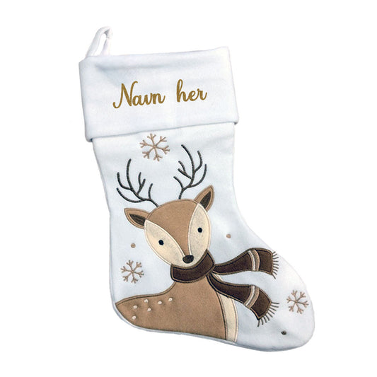 Hvit julestrømpe med brun reinsdyrmotiv, snøfnugg og brodert personlig navn på mansjetten.