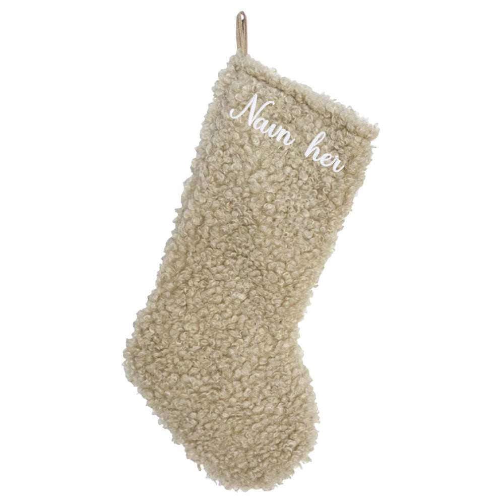 Beige julestrømpe i mykt teddy-stoff, med personlig brodert navn øverst.