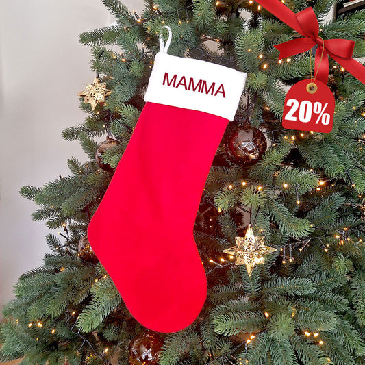 Klassisk rød julestrømpe i fløyel med personlig brodert navn, hengt på juletre – 20 % rabatt hos Eventyrprint.no. Perfekt personlig julegave til mamma, pappa eller barna.