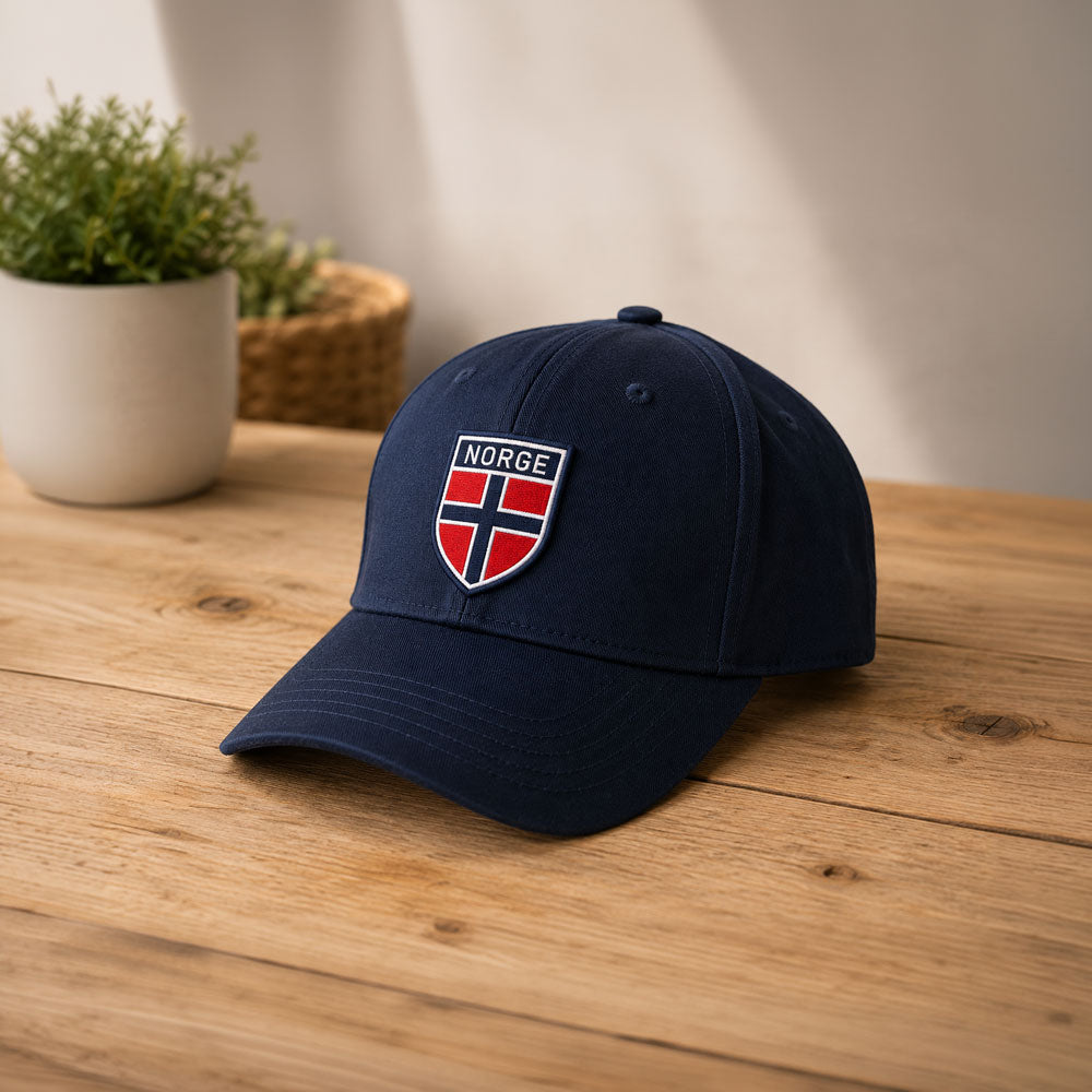 Norsk flagg iron patch montert på mørk blå caps.